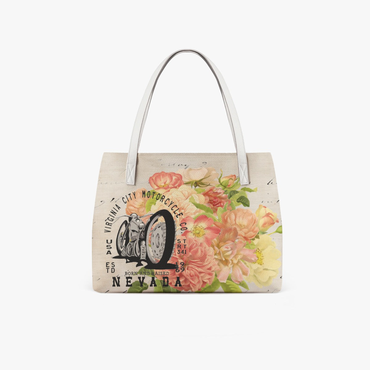 VCMCo. Born and Raised in Nevada vegan leather tote bag — front angle view showing structured shape, white handles, and floral motorcycle graphic with script detailing