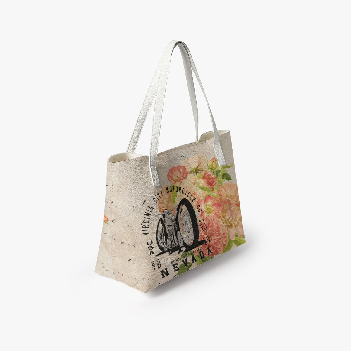 VCMCo. Born and Raised in Nevada vegan leather tote bag — side angle view showing structured shape, white handles, and floral motorcycle graphic with script detailing