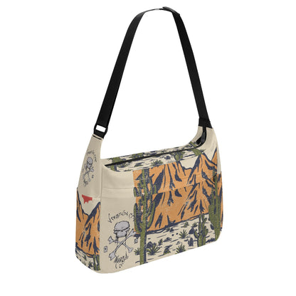 VCMCo. Skull & Crossbones Desert Messenger Bag — three quarter view - tan canvas with Virginia City Motorcycle Co. skull logo and desert mountain scene print, black adjustable shoulder strap