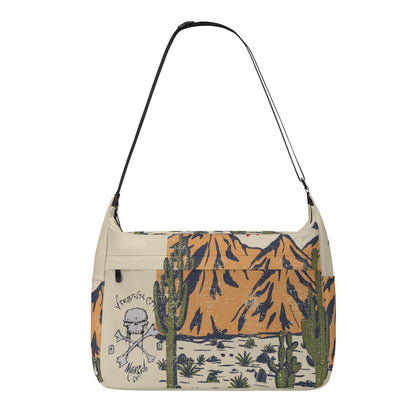 VCMCo. Skull & Crossbones Desert Messenger Bag — white canvas with Virginia City Motorcycle Co. skull logo and desert mountain scene print, black adjustable shoulder strap