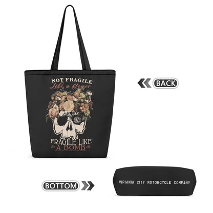 Black tote bag with a skull and floral graphic and the text 'NOT FRAGILE Life is a flayer FRAGILE LIKE A BOMB', shown alongside a matching black pouch labeled 'VIRGINIA CITY MOTORCYCLE COMPANY' on a white background.