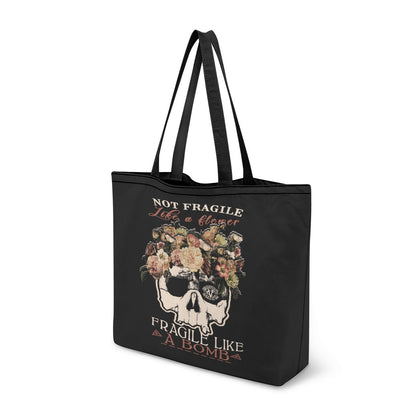 VCMCo. Fragile Like a Bomb canvas tote bag — black canvas with floral skull graphic and "Not Fragile Like a Flower, Fragile Like a Bomb" text in mixed script and block lettering